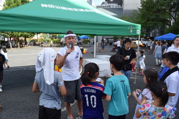 抽選会の司会は日比青年部長（小川町三丁目西町会）